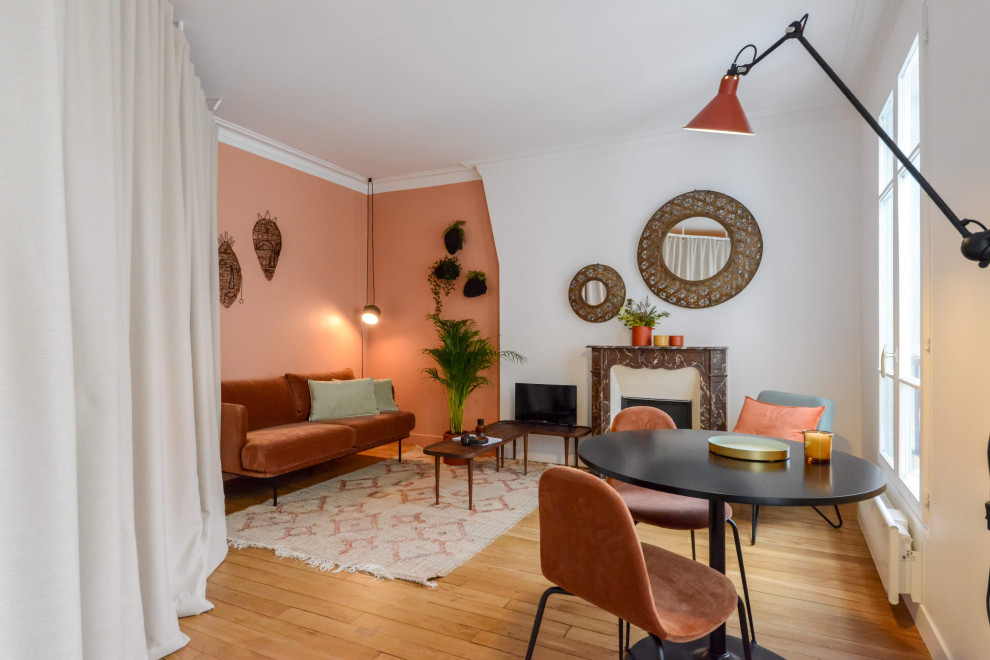 Modernes Wohnzimmer mit oranger Wandfarbe, braunem Holzboden, Kamin und braunem Boden in Paris