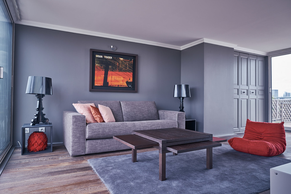 Foto di un soggiorno design di medie dimensioni e chiuso con pareti grigie, pavimento in legno massello medio, nessun camino e nessuna TV