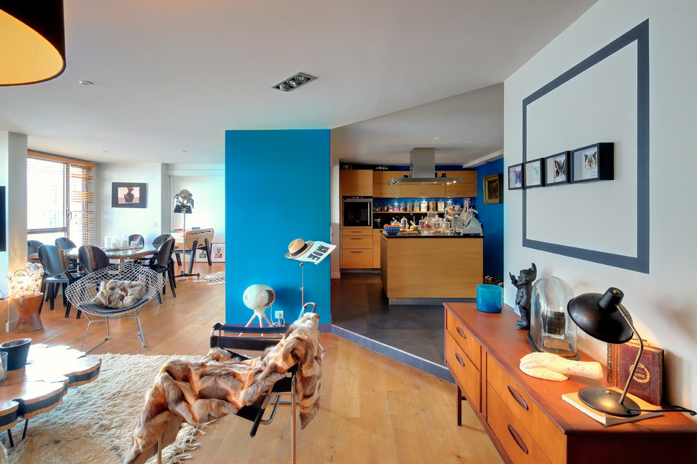 Esempio di un soggiorno design aperto con pareti blu, pavimento in legno massello medio e pavimento marrone