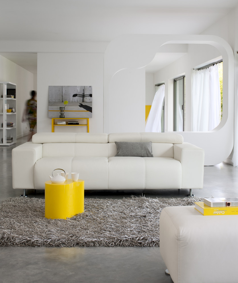 Exemple d'un salon gris et jaune tendance de taille moyenne et ouvert avec une salle de réception, un mur blanc et sol en béton ciré.