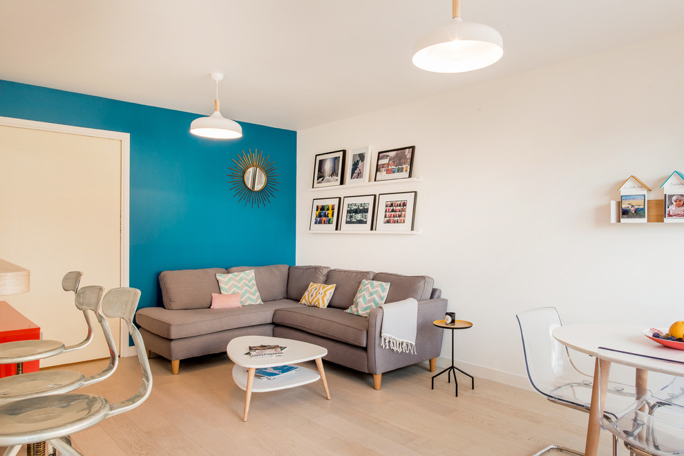 Пример оригинального дизайна: открытая, парадная гостиная комната среднего размера в современном стиле с синими стенами, светлым паркетным полом и акцентной стеной без камина, телевизора