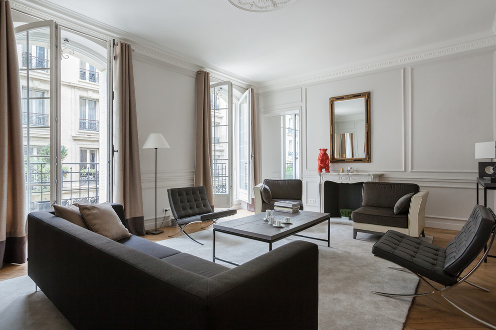 Großes, Repräsentatives, Fernseherloses, Offenes Modernes Wohnzimmer mit braunem Holzboden, Kamin und Kaminumrandung aus Stein in Paris