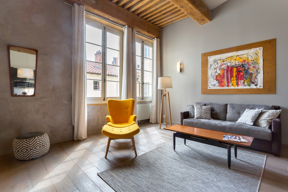 Foto de salón abierto contemporáneo con paredes grises y suelo de madera clara