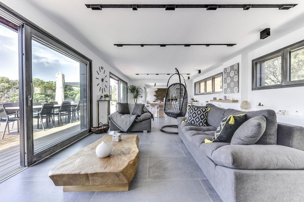 Idee per un soggiorno design aperto con pareti bianche e pavimento grigio