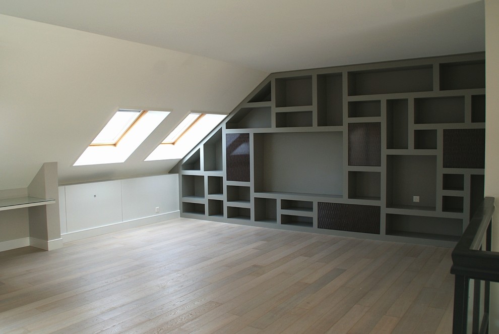 На фото: большая двухуровневая гостиная комната в стиле модернизм с с книжными шкафами и полками, белыми стенами, светлым паркетным полом и бежевым полом без телевизора, камина с
