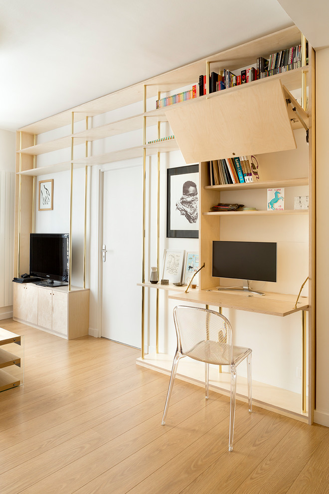 Ejemplo de biblioteca en casa abierta contemporánea pequeña sin chimenea con paredes blancas, suelo de madera clara, televisor independiente y suelo beige