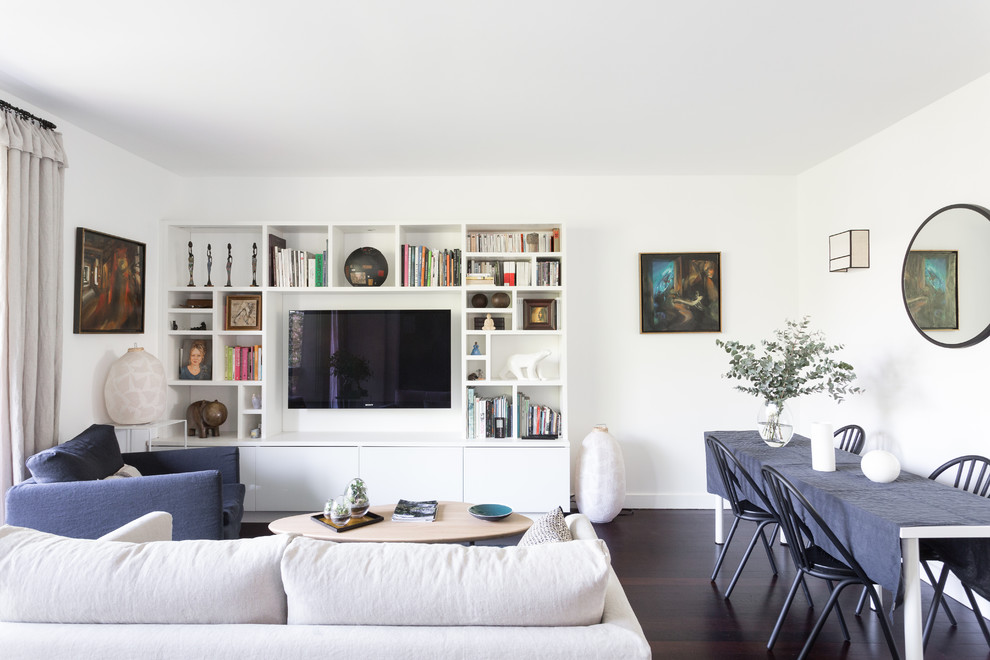 Idées déco pour un salon contemporain ouvert avec un mur blanc, parquet foncé, un téléviseur encastré et un sol marron.