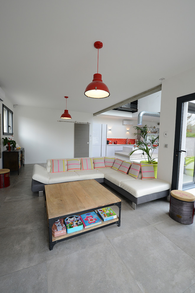 Mittelgroßes, Offenes Modernes Wohnzimmer mit weißer Wandfarbe, Keramikboden und grauem Boden in Marseille