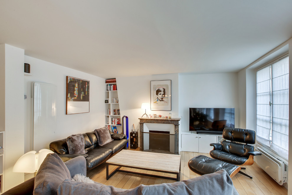 Idée de décoration pour un salon nordique avec un mur blanc, parquet clair, une cheminée standard, un téléviseur indépendant, un sol beige et éclairage.