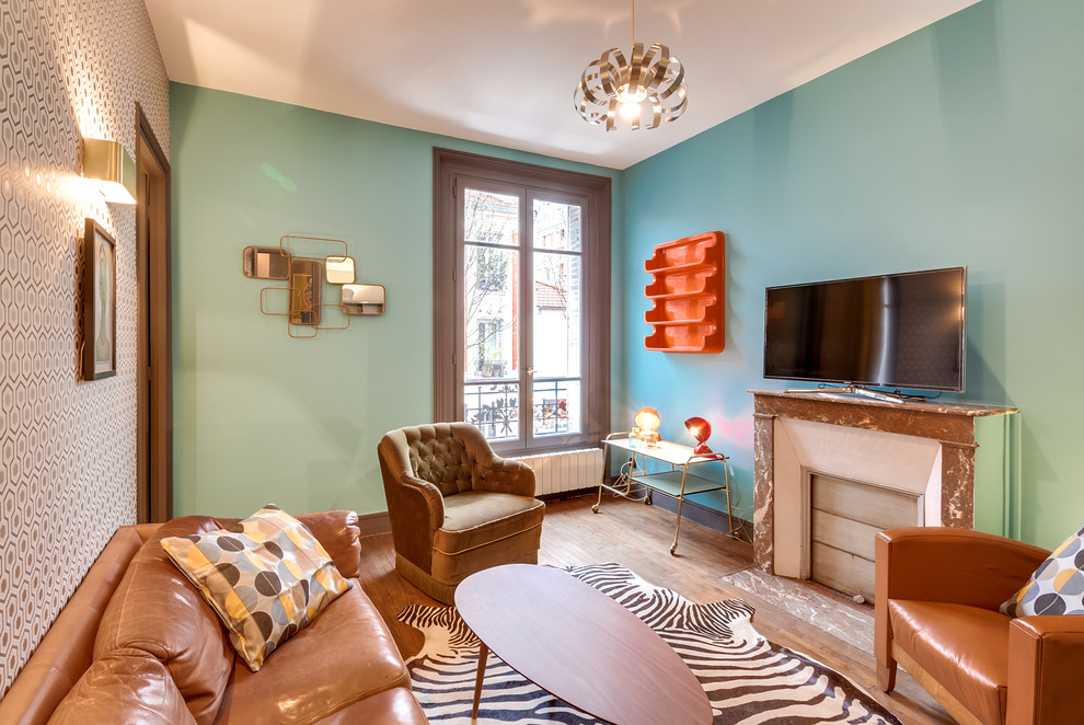 Cette photo montre un salon tendance de taille moyenne et fermé avec un mur multicolore, un sol en bois brun, une cheminée standard, un manteau de cheminée en pierre et un téléviseur indépendant.
