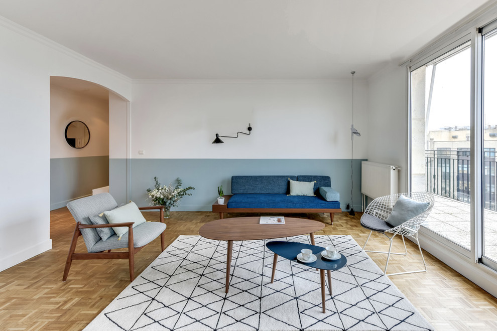 Свежая идея для дизайна: большая открытая гостиная комната в скандинавском стиле с светлым паркетным полом, разноцветными стенами и синим диваном без камина, телевизора - отличное фото интерьера