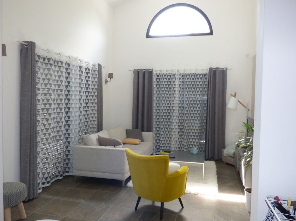 Modelo de salón abierto contemporáneo de tamaño medio sin chimenea con paredes blancas, suelo de baldosas de cerámica, televisor independiente y suelo gris