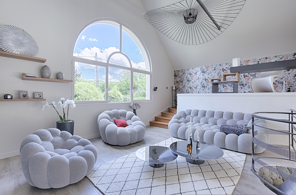 Idée de décoration pour un salon design avec un mur blanc, parquet clair et un sol gris.