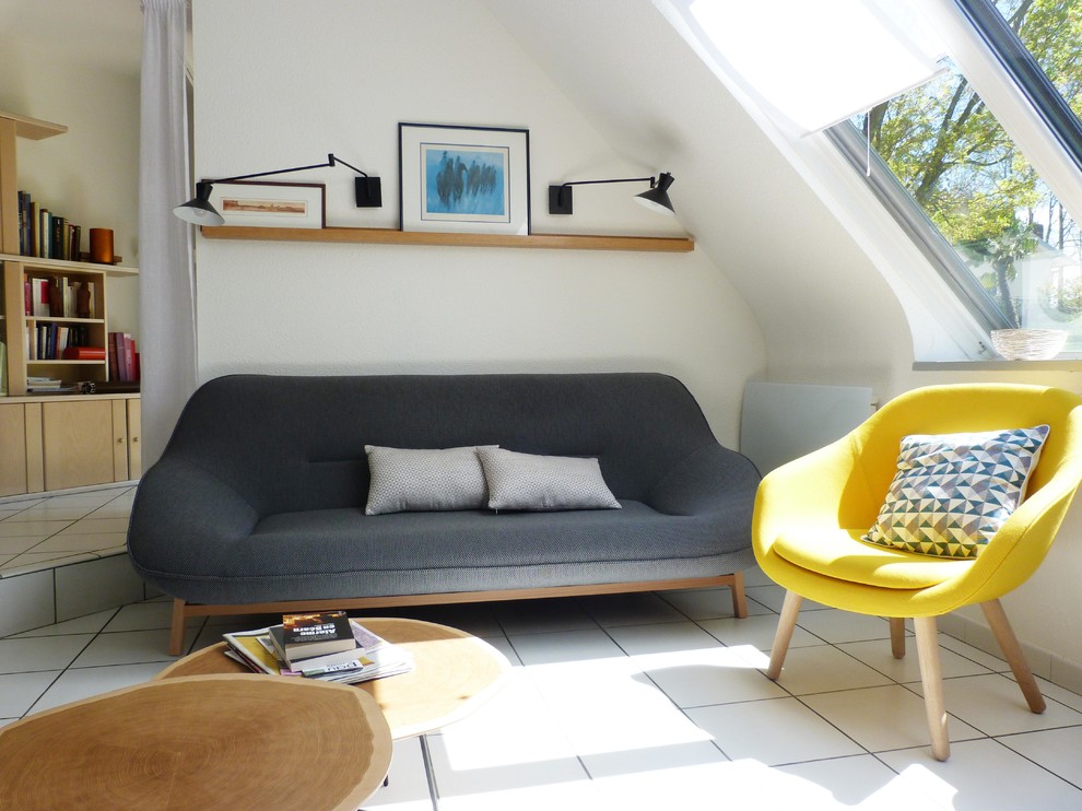 This is an example of a medium sized scandi open plan living room in Lyon with blue walls, a standard fireplace, a freestanding tv, ceramic flooring and white floors.