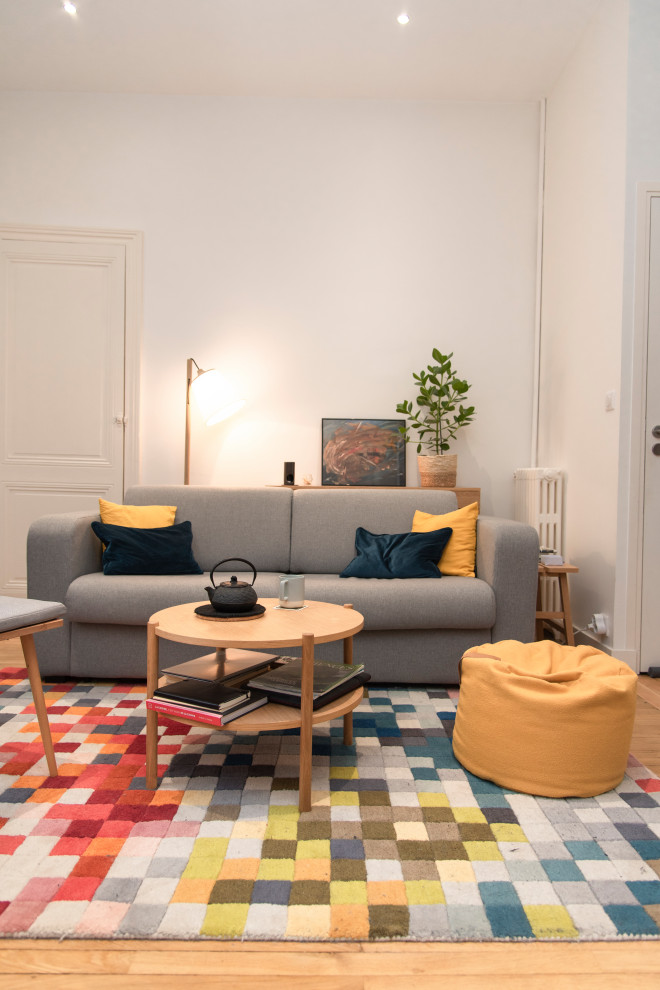 Foto di un piccolo soggiorno minimalista aperto con pareti bianche, parquet chiaro e TV autoportante
