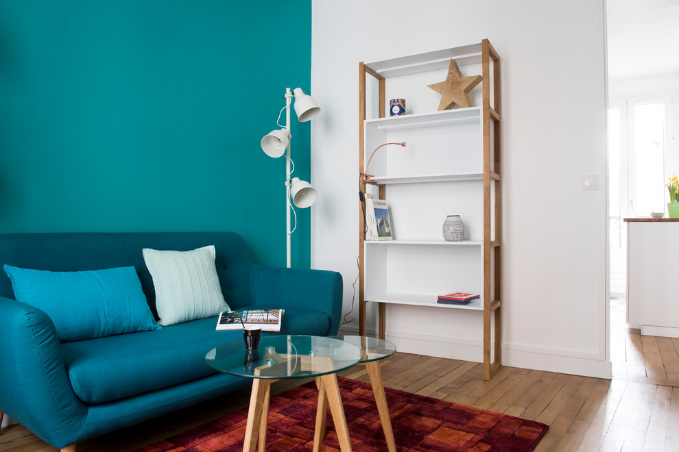 Esempio di un piccolo soggiorno moderno chiuso con libreria, pareti blu, parquet chiaro, nessun camino, nessuna TV e pavimento beige