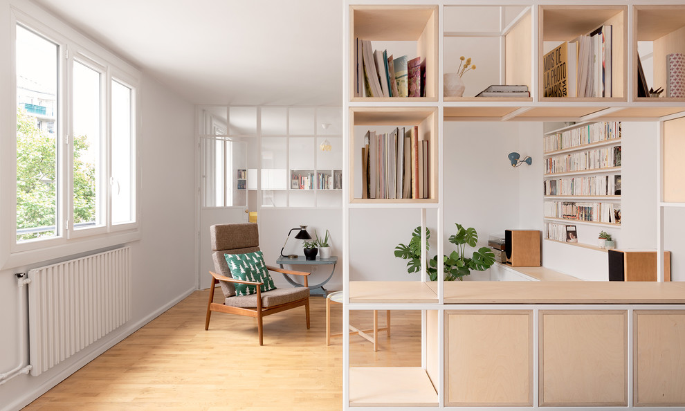 Imagen de biblioteca en casa nórdica de tamaño medio con paredes blancas, suelo de madera clara y televisor independiente