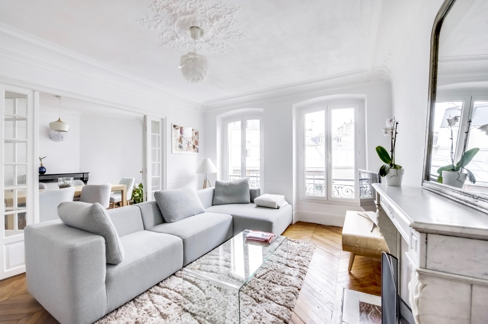 Cette photo montre un grand salon scandinave ouvert avec un mur blanc, parquet clair, une cheminée standard, un téléviseur indépendant et éclairage.