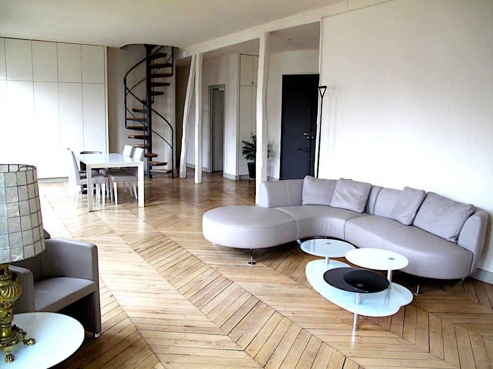 Modelo de salón para visitas abierto bohemio grande sin chimenea y televisor con paredes grises y suelo de madera clara