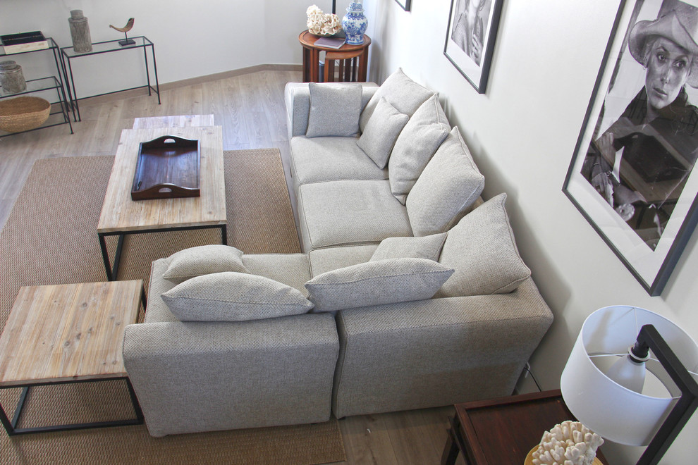 Immagine di un grande soggiorno minimal aperto con pareti beige, parquet chiaro e TV a parete