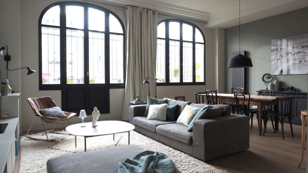 Imagen de salón abierto clásico renovado grande con suelo marrón, paredes verdes, suelo de madera en tonos medios y cortinas