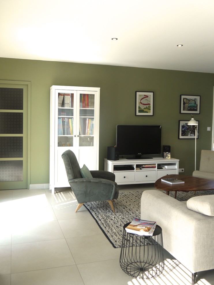 Пример оригинального дизайна: открытая гостиная комната среднего размера в скандинавском стиле с с книжными шкафами и полками, зелеными стенами, полом из керамической плитки, отдельно стоящим телевизором и серым полом без камина