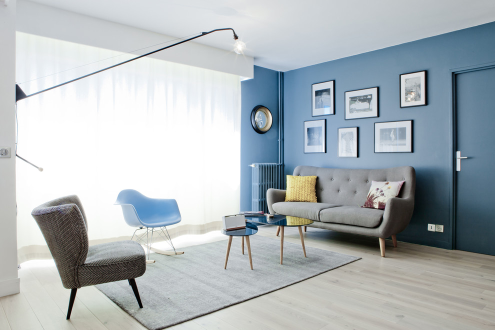 Mittelgroßes, Repräsentatives, Offenes Nordisches Wohnzimmer mit blauer Wandfarbe, hellem Holzboden und grauem Boden in Marseille