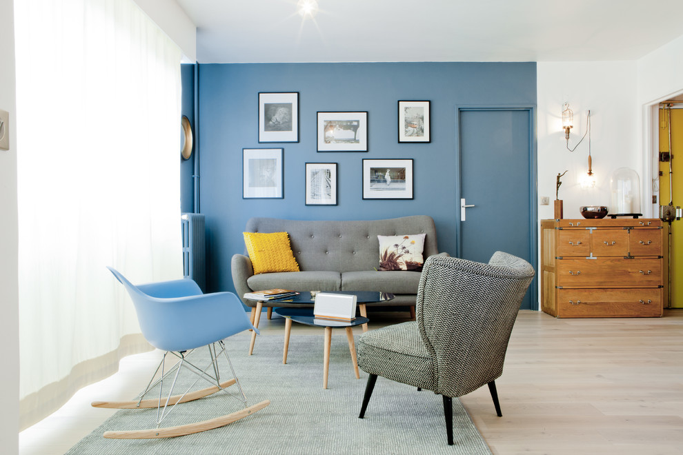 Cette image montre un salon nordique de taille moyenne et ouvert avec une salle de réception, un mur bleu, parquet clair et un sol gris.
