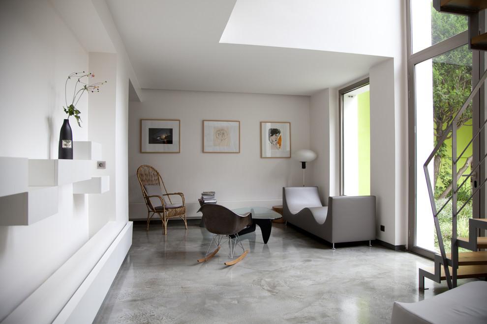 Свежая идея для дизайна: парадная, открытая гостиная комната среднего размера в современном стиле с белыми стенами и бетонным полом без камина, телевизора - отличное фото интерьера