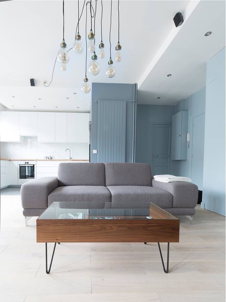 Imagen de salón abierto contemporáneo de tamaño medio sin chimenea con paredes azules, suelo de madera clara y televisor colgado en la pared