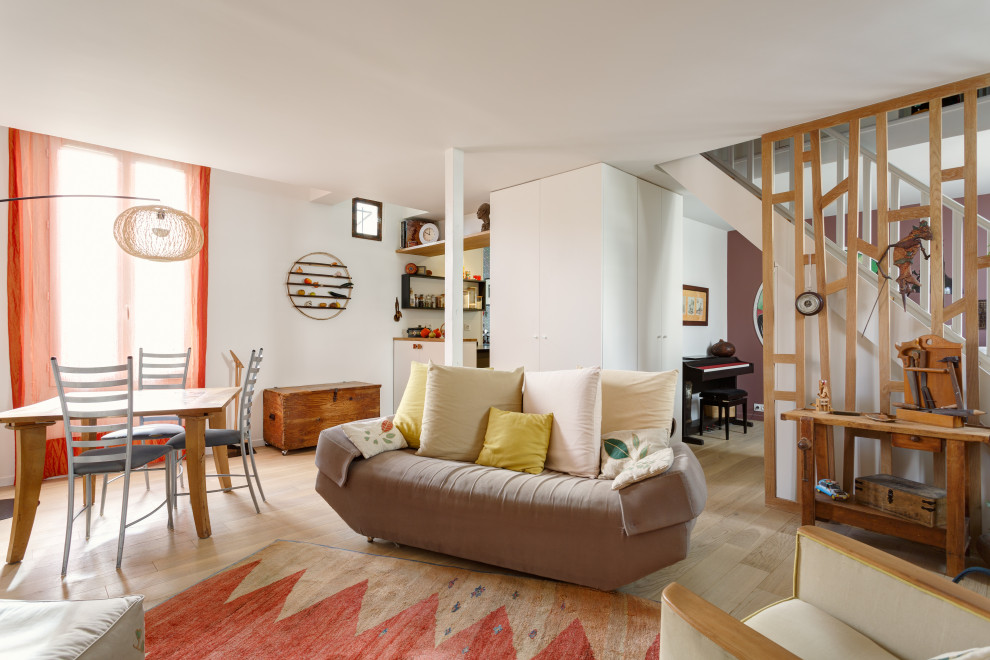 Foto de salón abierto contemporáneo de tamaño medio con paredes blancas, suelo de madera clara y suelo beige