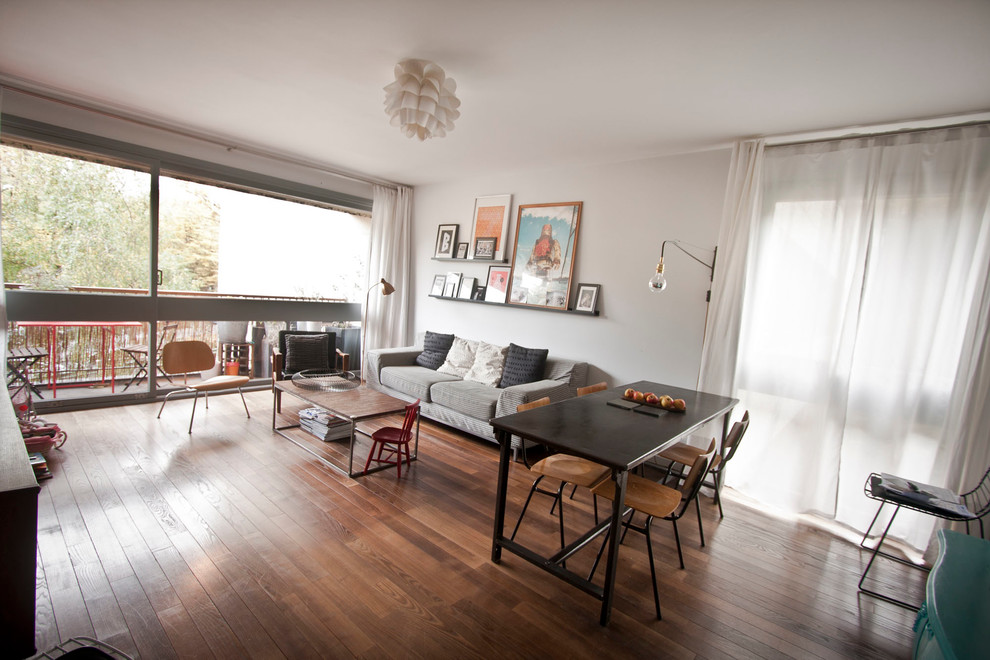 Imagen de salón para visitas abierto nórdico de tamaño medio sin chimenea con televisor independiente, paredes grises y suelo de madera en tonos medios