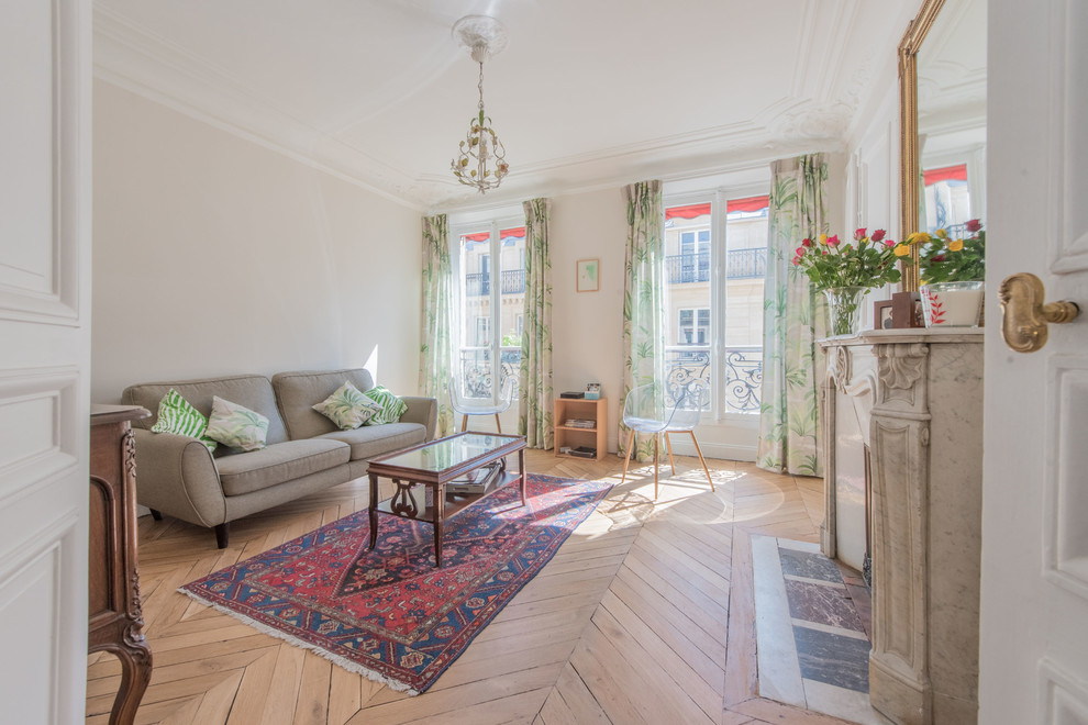 Großes, Fernseherloses, Abgetrenntes Klassisches Wohnzimmer mit beiger Wandfarbe, braunem Holzboden, Kamin, Kaminumrandung aus Stein und beigem Boden in Paris