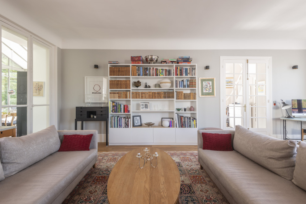 Cette image montre un salon design avec un mur gris, un sol en bois brun et un sol marron.