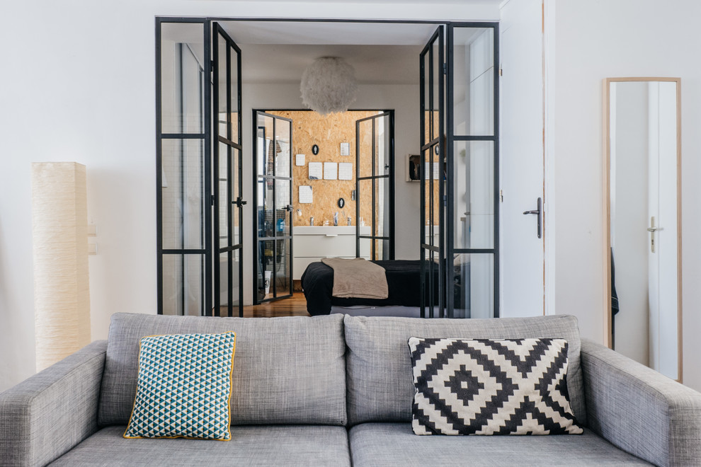 Mittelgroßes, Abgetrenntes Industrial Wohnzimmer mit weißer Wandfarbe und hellem Holzboden in Paris