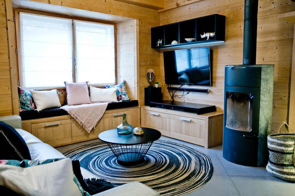 Immagine di un grande soggiorno tropicale aperto con pavimento con piastrelle in ceramica, stufa a legna e pavimento grigio