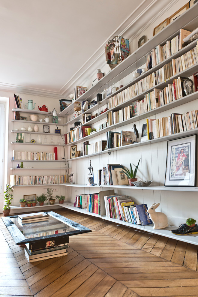 Diseño de biblioteca en casa abierta actual de tamaño medio sin chimenea y televisor con paredes blancas y suelo de madera en tonos medios