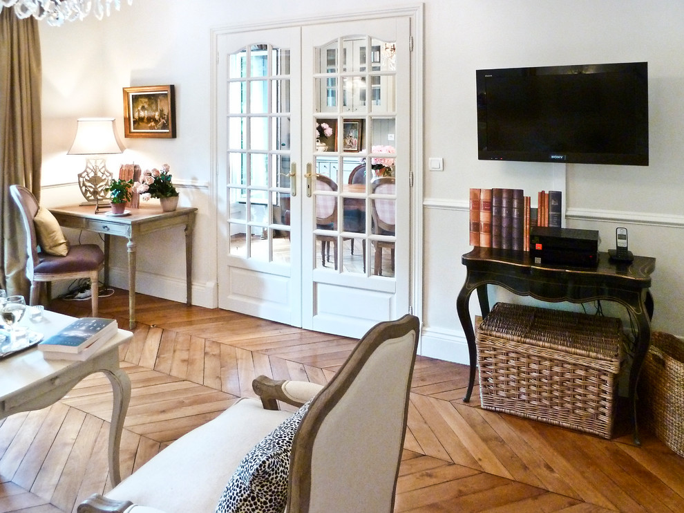 Inspiration for a contemporary enclosed living room in Paris with beige walls, medium hardwood flooring, no fireplace and a wall mounted tv.