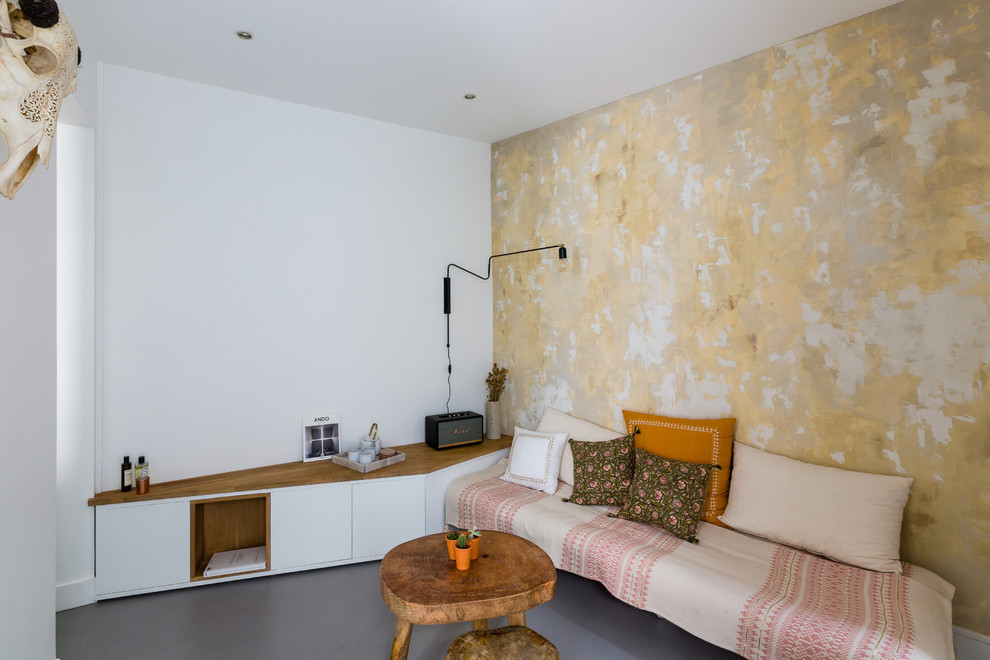 Kleines, Fernseherloses, Offenes Skandinavisches Wohnzimmer ohne Kamin mit weißer Wandfarbe, Betonboden und grauem Boden in Paris
