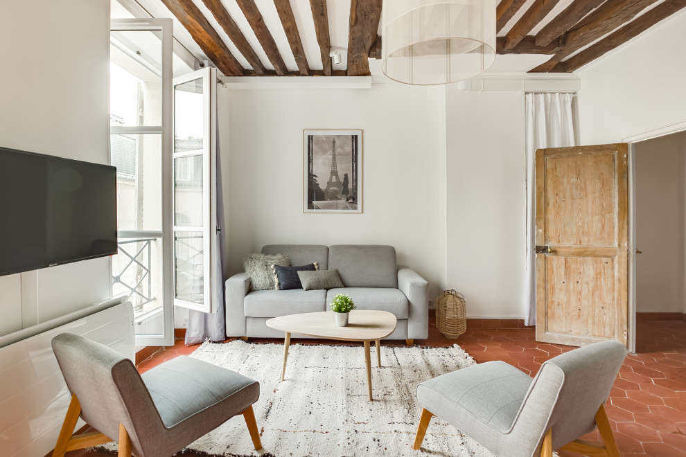Offenes Nordisches Wohnzimmer ohne Kamin mit weißer Wandfarbe, Terrakottaboden, TV-Wand und rotem Boden in Paris