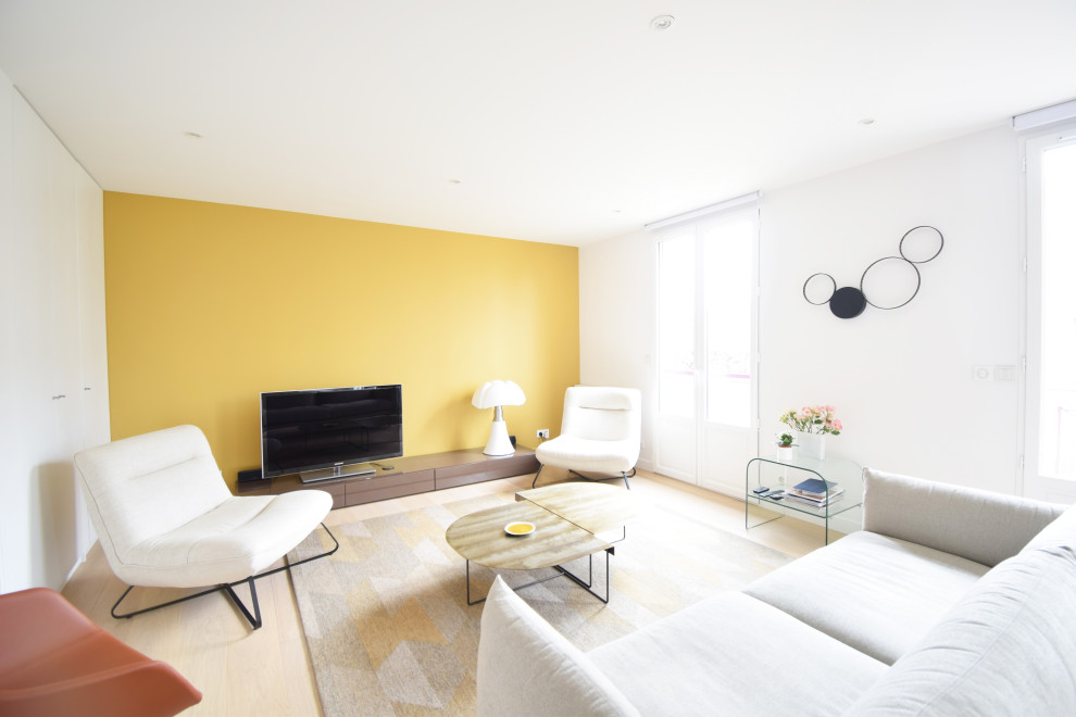 Источник вдохновения для домашнего уюта: большая парадная, открытая гостиная комната в современном стиле с желтыми стенами, светлым паркетным полом, отдельно стоящим телевизором и белым полом без камина