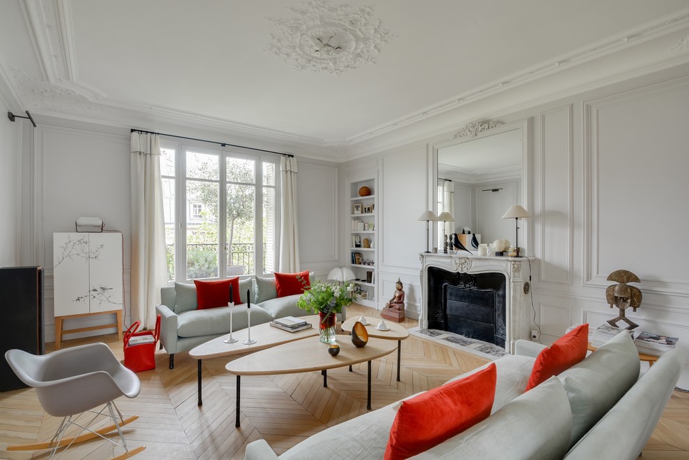 This is an example of a large traditional formal enclosed living room in Paris with white walls, light hardwood flooring, a standard fireplace, no tv and a stone fireplace surround.