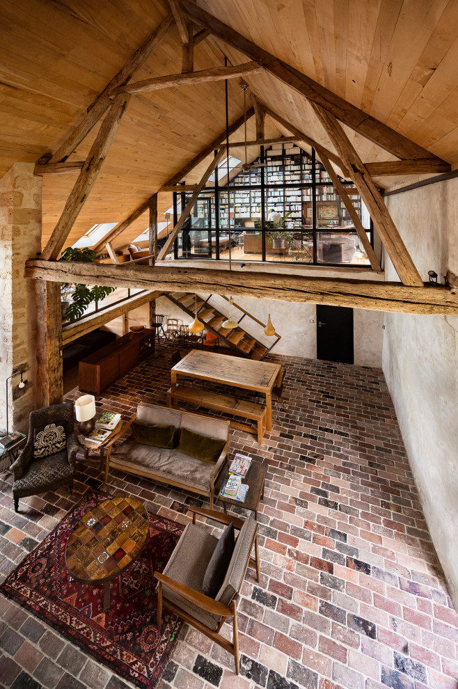 Large rural enclosed living room in Le Havre with a reading nook, beige walls, brick flooring, a wood burning stove, a metal fireplace surround, a concealed tv, multi-coloured floors and a wood ceiling.