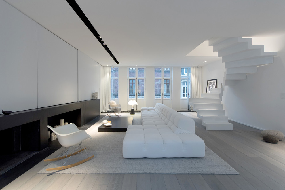 Diseño de salón para visitas abierto actual grande sin chimenea y televisor con paredes blancas y suelo de madera clara