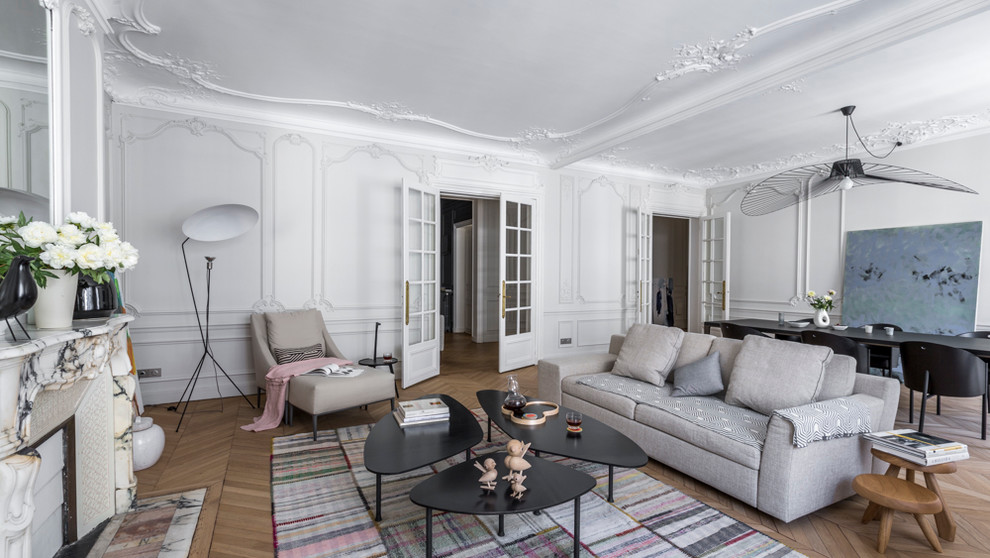 Großes, Abgetrenntes, Repräsentatives, Fernseherloses Klassisches Wohnzimmer mit weißer Wandfarbe, braunem Holzboden und Kamin in Paris