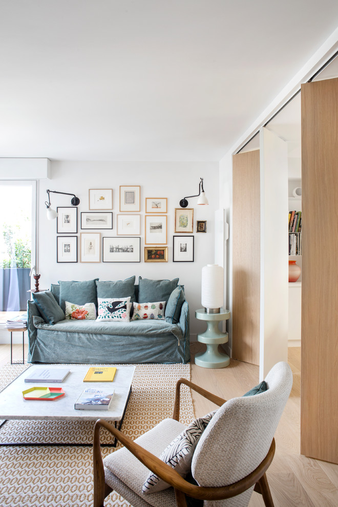 Esempio di un soggiorno design con pareti bianche, parquet chiaro e pavimento beige