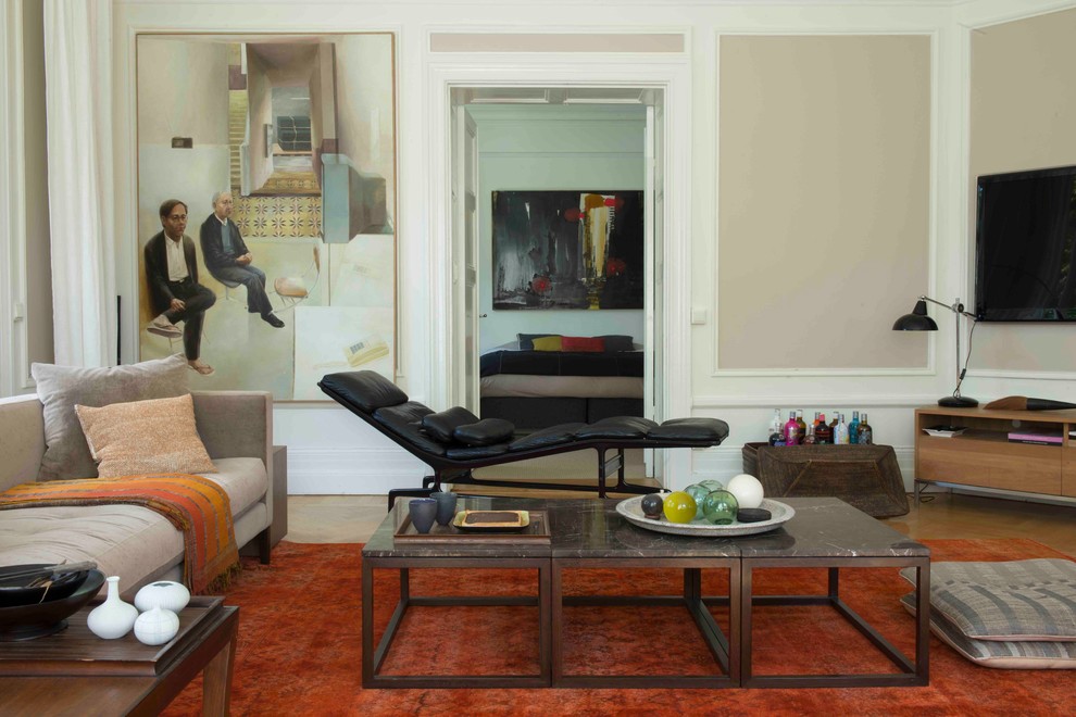 На фото: гостиная комната в стиле неоклассика (современная классика) с бежевыми стенами, паркетным полом среднего тона, телевизором на стене и коричневым полом с