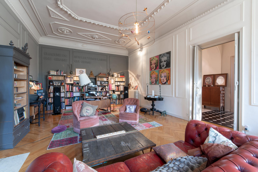 Abgetrenntes Stilmix Wohnzimmer mit grauer Wandfarbe, braunem Holzboden und braunem Boden in Angers
