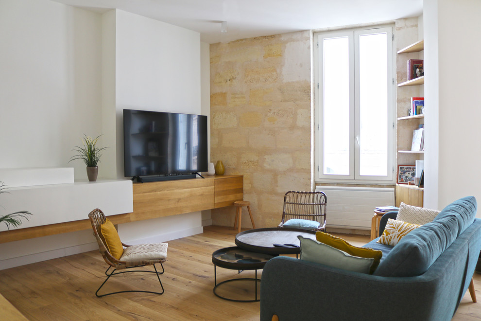 Aménagement d'un grand salon contemporain ouvert avec un mur blanc, parquet clair, un téléviseur indépendant et un sol marron.