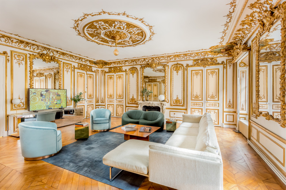 Inspiration for a large classic enclosed living room in Paris with a music area, white walls, medium hardwood flooring, a standard fireplace, a plastered fireplace surround, a freestanding tv, brown floors and wainscoting.